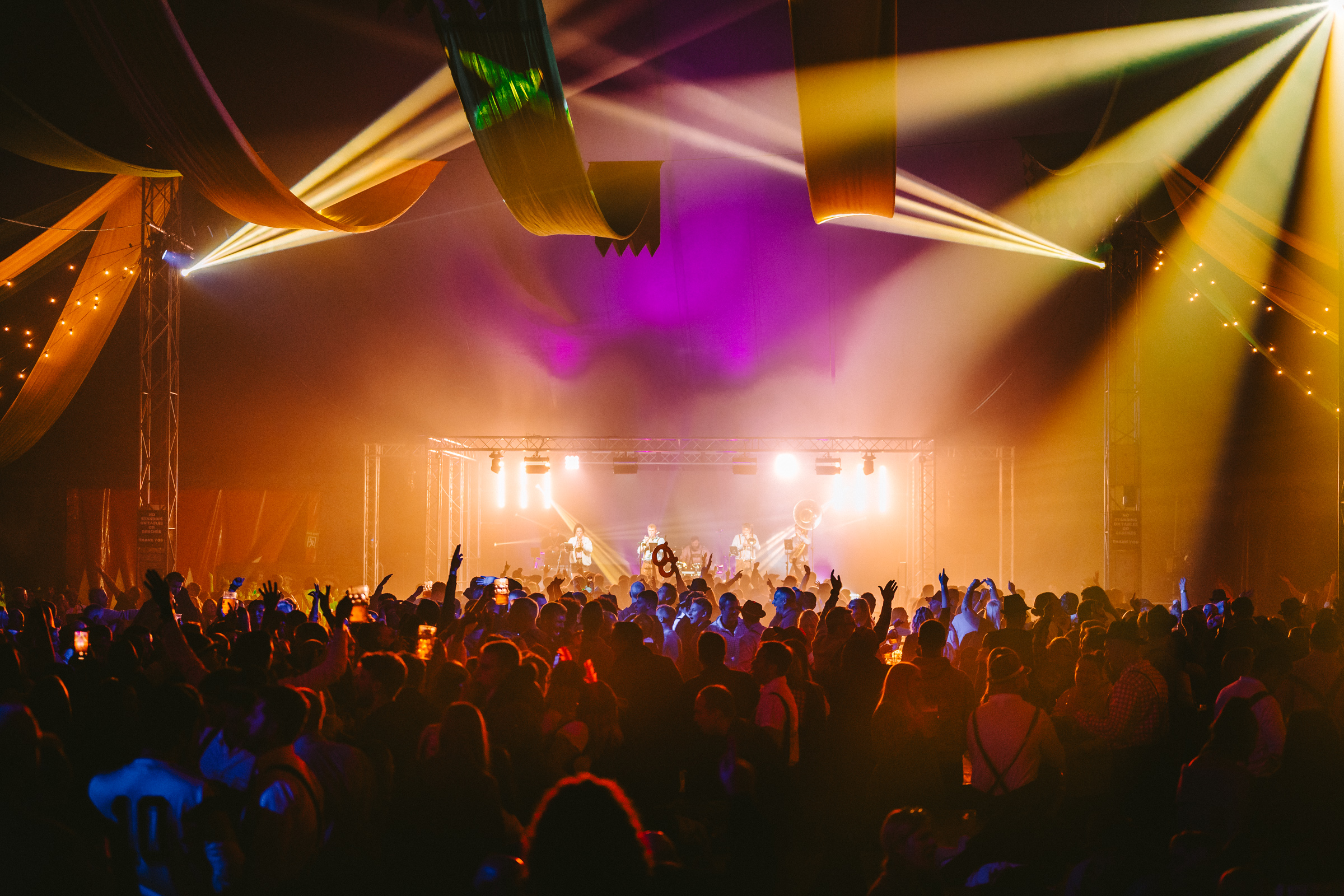 Crowd enjoying a live Oktoberfest event under stage lights